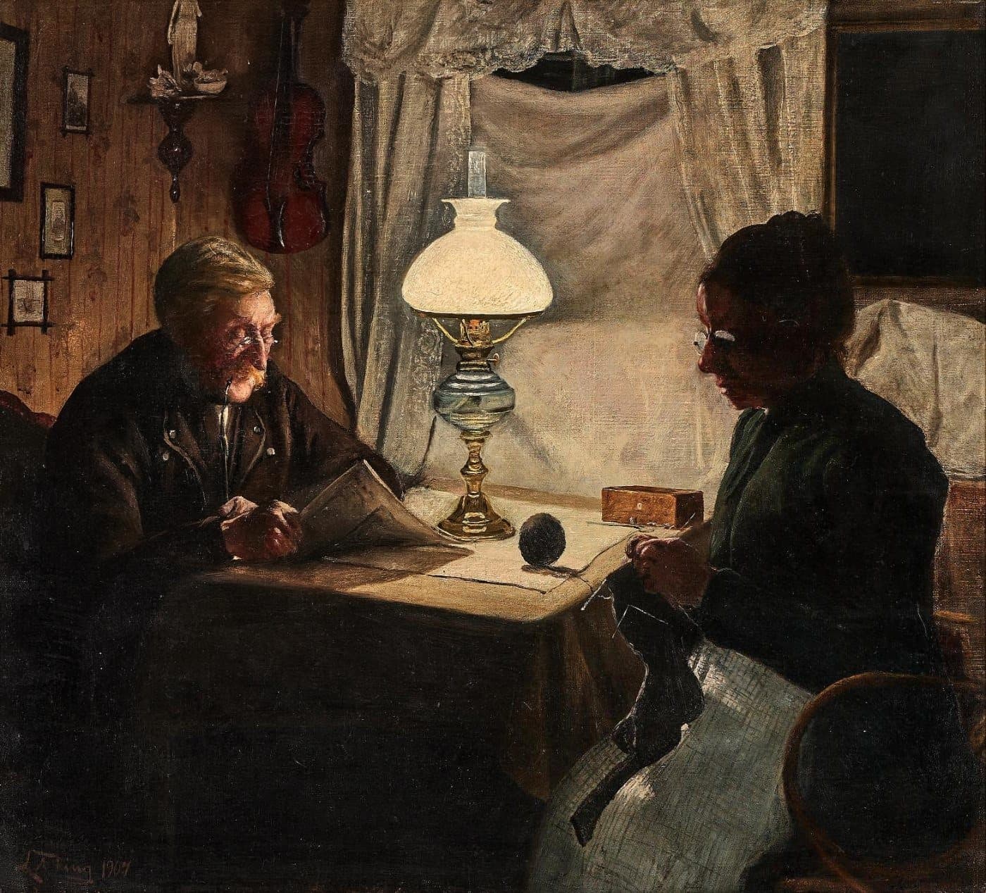 An old man reads under an oil lamp at a table while his wife knits beside him in a dim, warm room